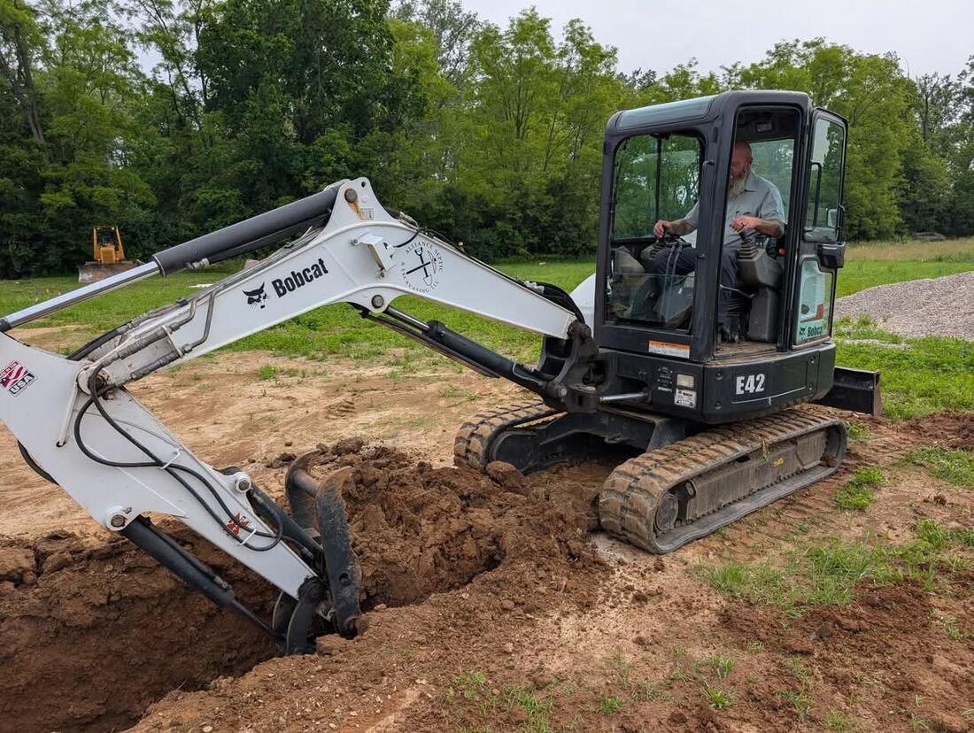 Alliance Septic mini excavator cutting a trench for a septic line